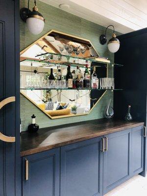 3/16" Antique mirror, edges of mirror covered with brass metal. 1/2" clear shelves installed on mirror with Satin brass rod hardware.