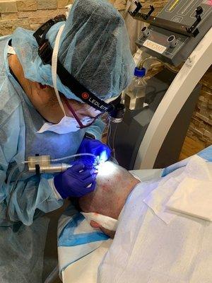 NeoGraft Master Tech Daryl Watson working on a hair transplant patient.