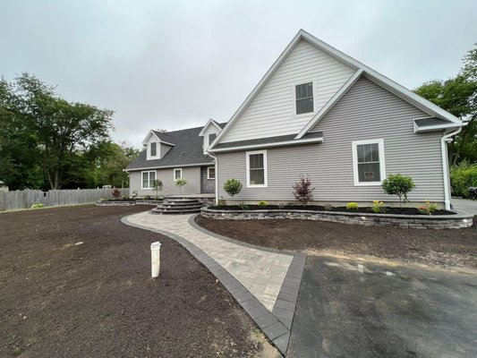 Steps and garden wall with lighting and paver walkway leading to driveway.