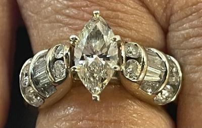 14kt yellow gold engagement ring. center diamond marquee 1.75ct surrounding tapered begets and brilliant cut diamonds