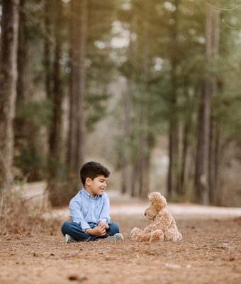 Portrait of a boy talking to his teddy bear