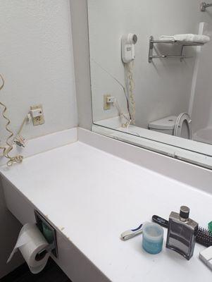 Cracked bathroom mirror with cigarette burns from sitting smokers