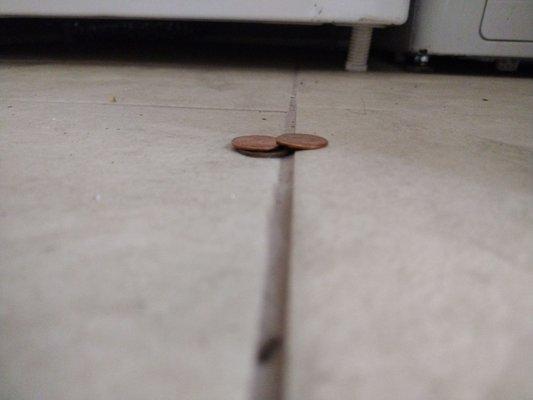 Tiles installed to where the floor feels uneven. This tile edge is 2 pennies higher than the next tile edge. It's everywhere.