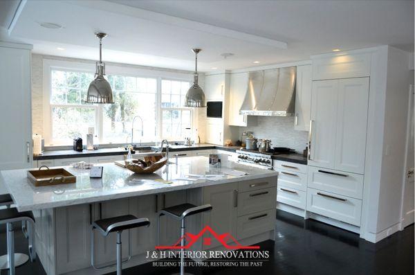 Open concept kitchen white shaker cabinetry 
 , massive island with fridge panels.