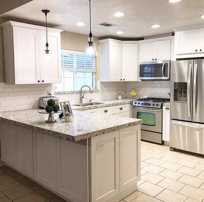 White shaker style cabinets with a beautiful Monet quartz and a glossy white subways tile backsplash to tie it all in.