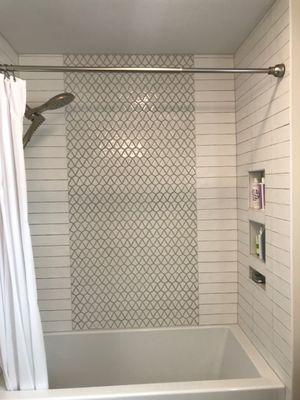 Custom shower tile with arrowhead mosaic waterfall and niche.