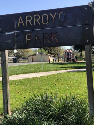 Signage with hoops, children's playground, bathrooms in rear.