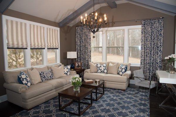 Pillows, Roman shades and panels finish this living room in shades of navy. Design by Judy Diamond.