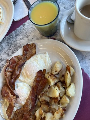 2 Eggs and a Toast, sides of homemade fries and bacon.