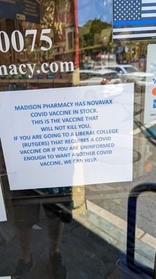 A sign in Madison Pharmacy's front door produced by the pharmacist, Frank Iannarone, spreading conspiracy theories about the COVID vaccine.