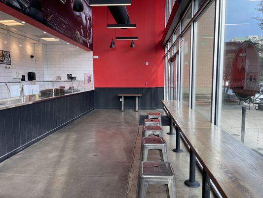 Barstools and a long table inside the restaurant.