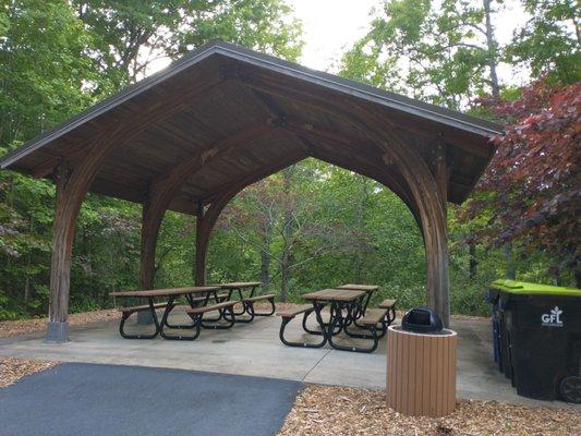 Beautiful small picnic pavilion with other tables and many benches around the park