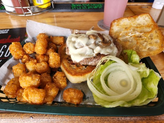 Mushroom Swiss burger on ciabatta bread with tots.