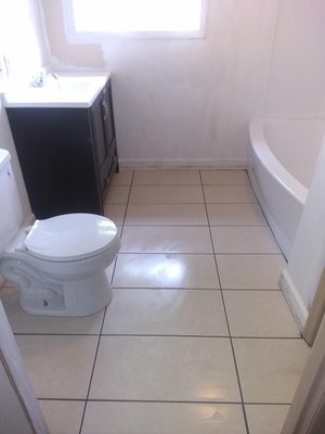 Bathroom remodel involving tile flooring, new cabinetry, sink, faucets, toilet, bathtub, etc.