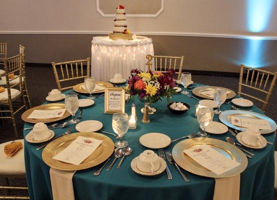 Gold pedestal vase and mixed flowers. Carrie also supplied and built the floral design on the cake in the background.