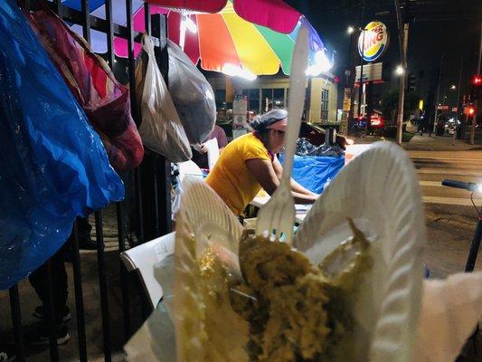 Holding a tamale in front of Rosa's stand. One woman show!