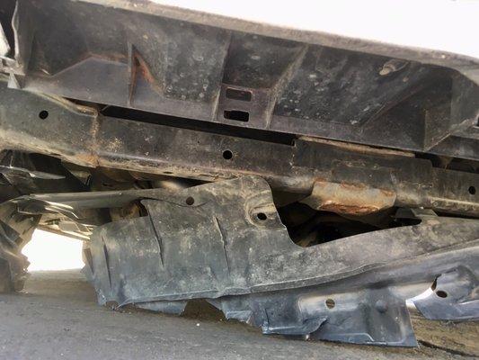 Splash shield damaged by roadside debris 300 miles prior to partially detaching from car