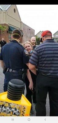 Brenda being held back from getting to protesters.