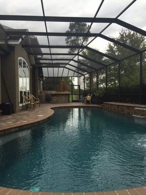 A beautiful rescreening,Florida glass(vinyl coated screen) has been installed at far end to keep the outdoor kitchen area dry