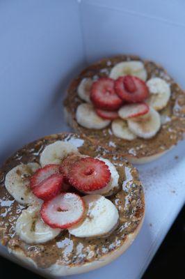 Nut and seed butter bagel with banana, strawberry, and agave syrup.