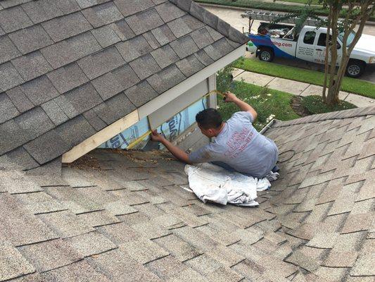 Technician replacing damaged wood on a dormer.