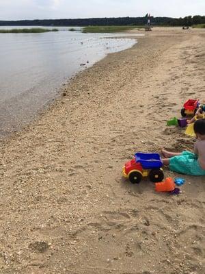 Meir blissfully playing with his sand toys at this beach