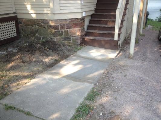 small repair of a broked up section of sidewalk.