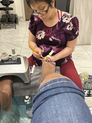 Doing wonderful job on my pedicure. Taking her time. Make sure it is done right.