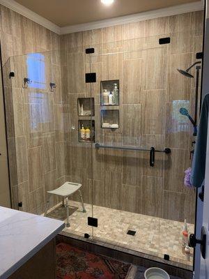 Frameless glass shower door and grab bar installed by JV Glass & Mirror on 4-12-2022