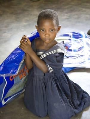 A girl receives a mosquito net- KUDO, Malawi