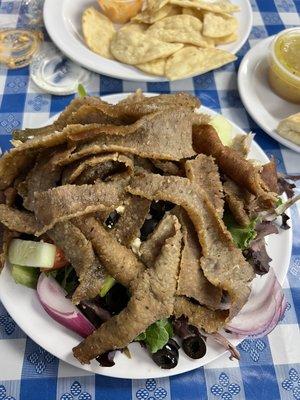 Small Greek salad with Gyro meat. Included on the side are a Dolma (stuffed grape leaf), a warm pita, and dressing.