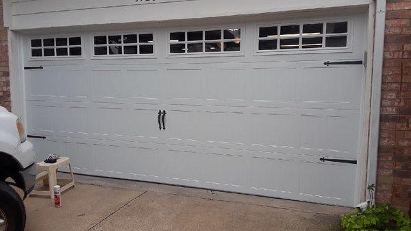 New carriage house door with full row of windows with inserts and standard handles and hinge straps.