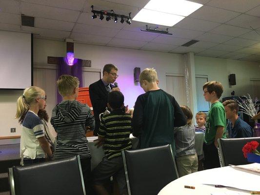 Pastor Zach teaches children about the Lord's Supper