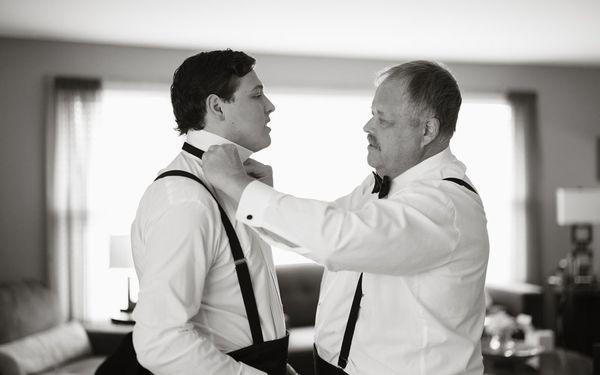 Father helping groom get ready, black and white images