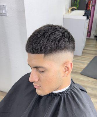 High skin fade with texture cut off on top.