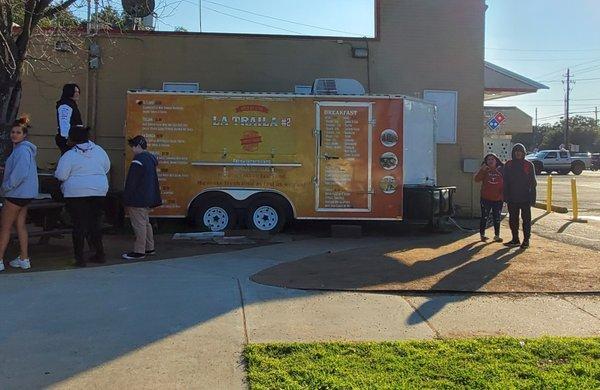 Food truck open during breakfast and lunch hours on side of mart