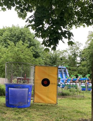 Dunk tank with dual giant water slide and slip and slide in the rear.