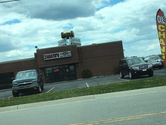 Super sweet neon convertible on top of the building.