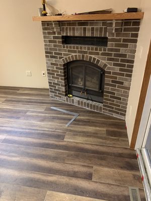 Custom LVP install around an existing fireplace.