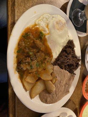 Combination plate: barbacoa, carne guisada, eggs, potatoes and beans.