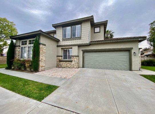 Charming townhouse with inviting patio, cushioned seating, and lush plants.