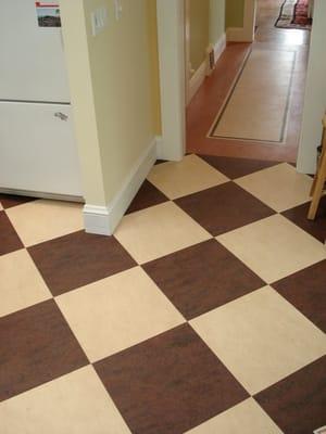 Checker board design in brown and cream Marmoleum linoleum tiles.