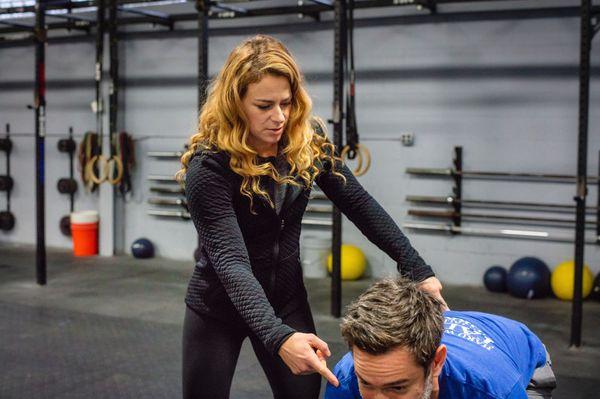 Coach Kate making sure Aaron's shoulders and hips are in the right position before the lift.