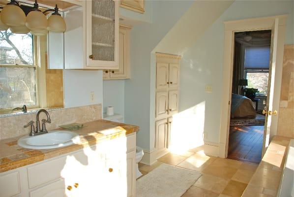 Master and Commander Queen suite's bathroom with stone tiles, a full spa tub and shower.