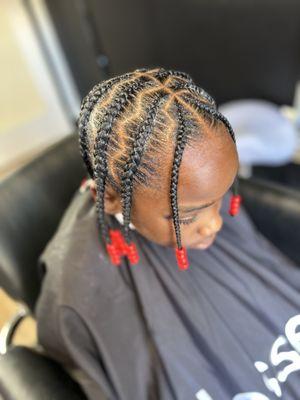 Kids stitch braids with beads.