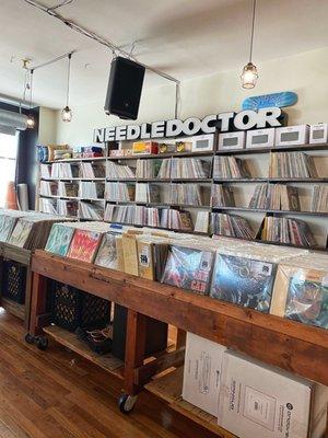 Large wall of back stock by the Needle Doctor sign.