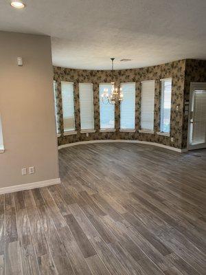 New flooring installation in living room, dining room, and kitchen.