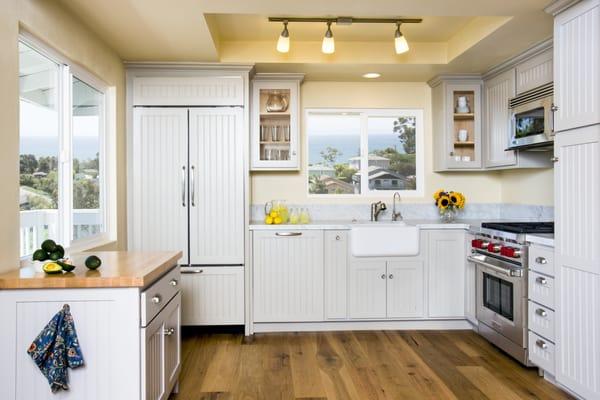 The countertop and splash are White Carrera honed marble while the unfixed island has a warm butcher block top.