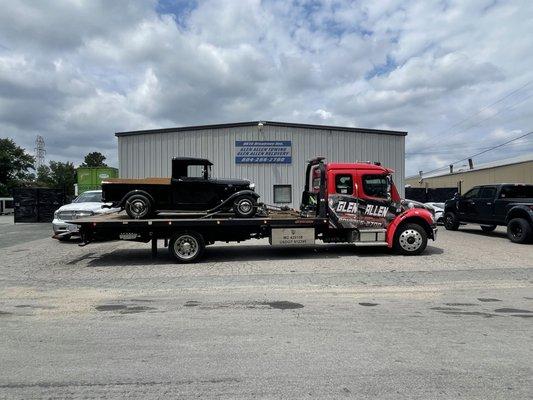 Tow truck carrying an antique vehicle