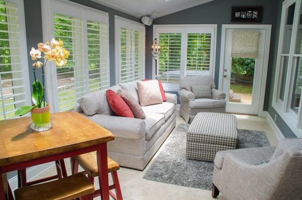 Beautiful sunroom with shutters and roman shades. BlindPros.com 910.444.3999